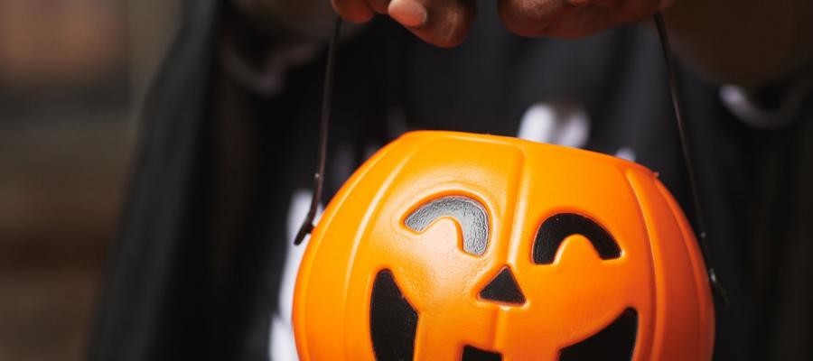 Trick-or-treating boy with jack-o-lantern bucket